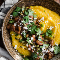 Close-up overhead photo of pumpkin polenta topped with chipotle pinto beans and cilantro