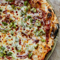 Close-up pizza with casteveltrano olives and red onions.