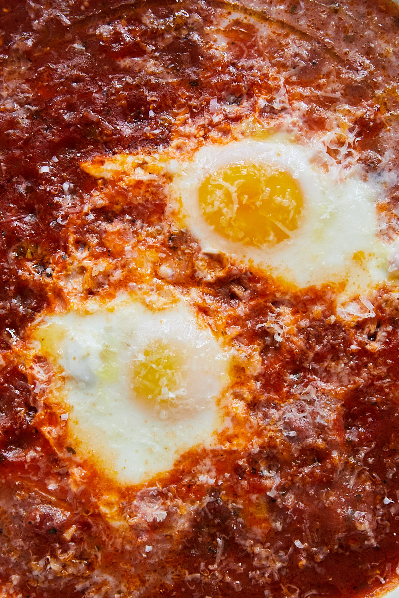 close-up of eggs cooked in a thick tomato sauce.