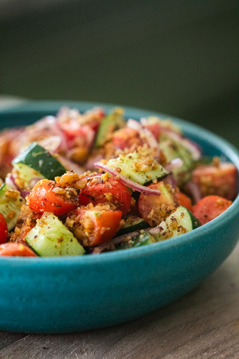 photo of a crispy chickpea cucumber salad in a teal bowl.