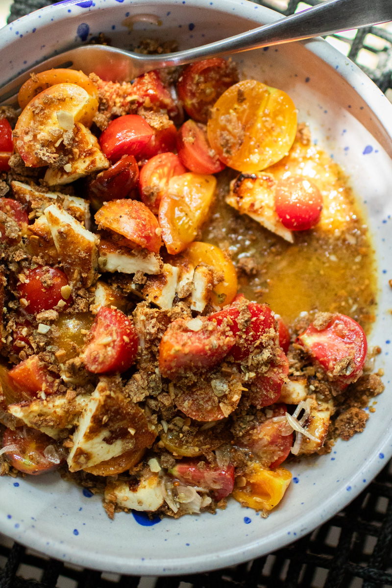 Close-up of halloumi and tomatoes with a mustard vinaigrette.