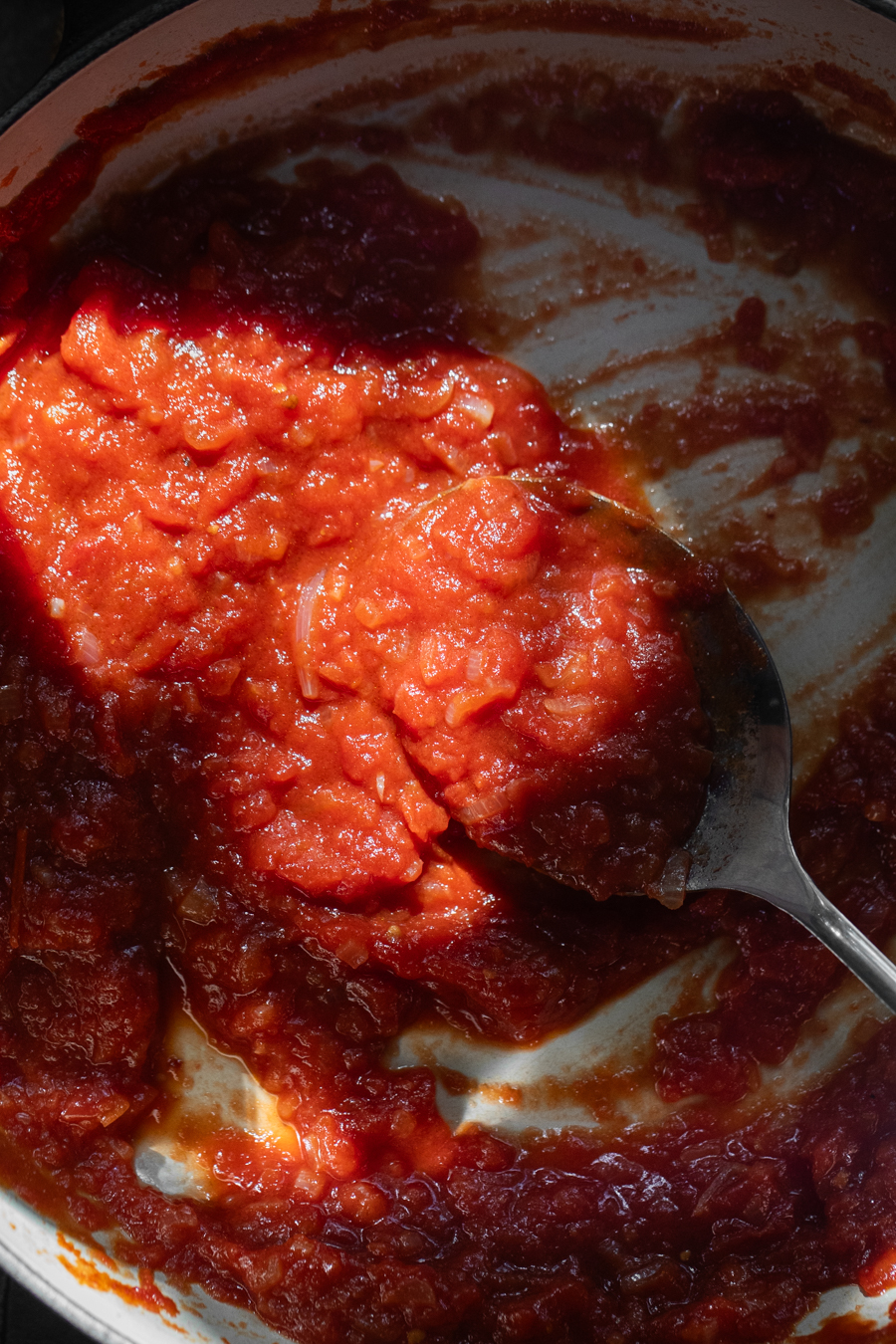 Harissa Tomato Sauce with a spoon scooping out of a pot
